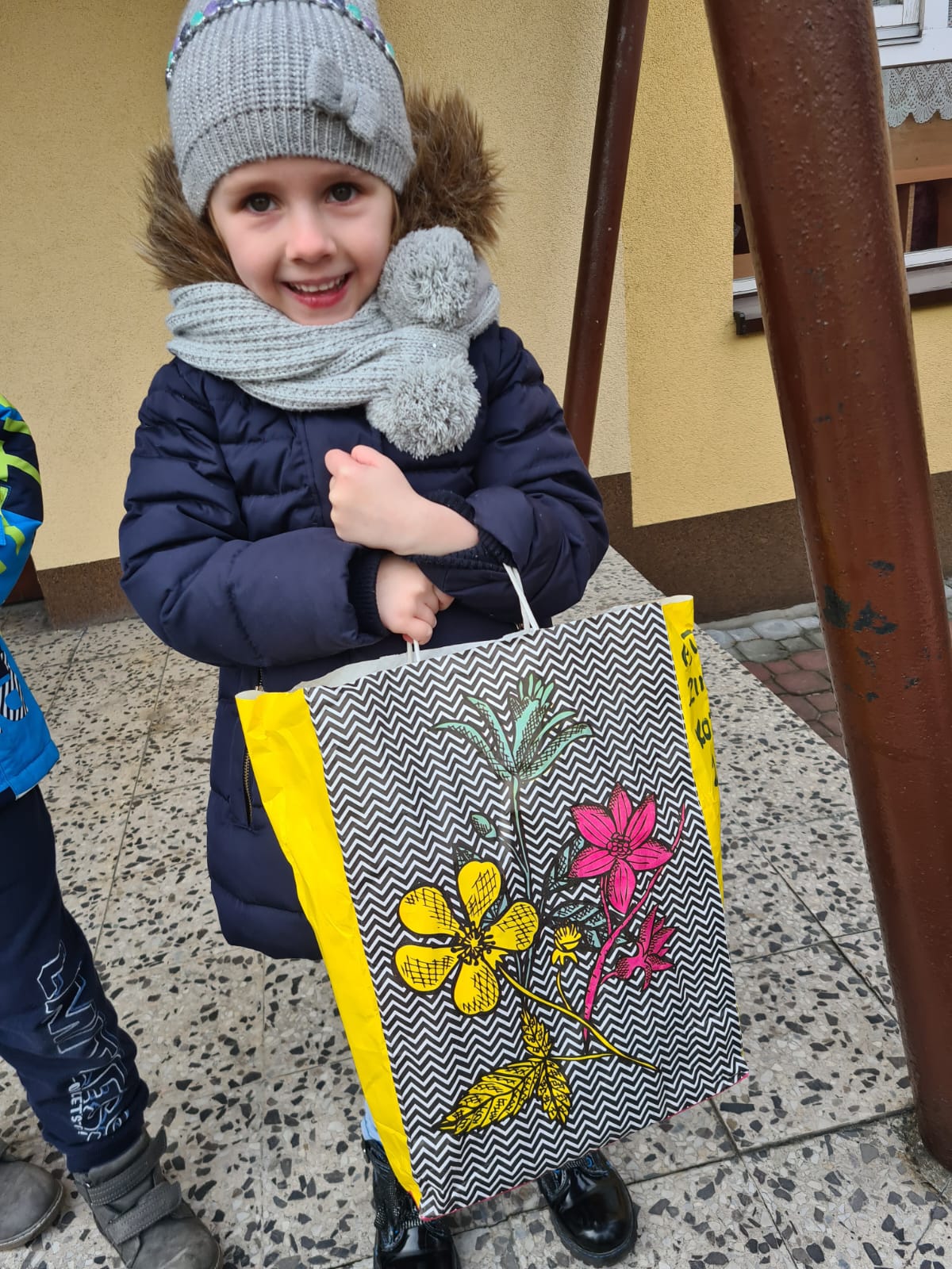 Dziewczynka niesie torbę z rzeczami dla uchodźców z  Ukrainy