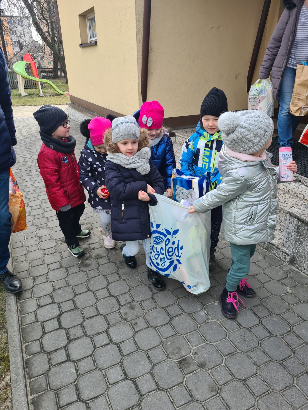 grupa dzieci niesie dużą torbę z darami dla uchodźców z Ukrainy