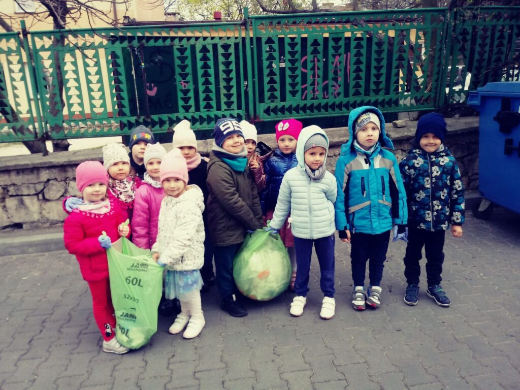 Grupa przedszkolaków i z workami pełnymi śmieci