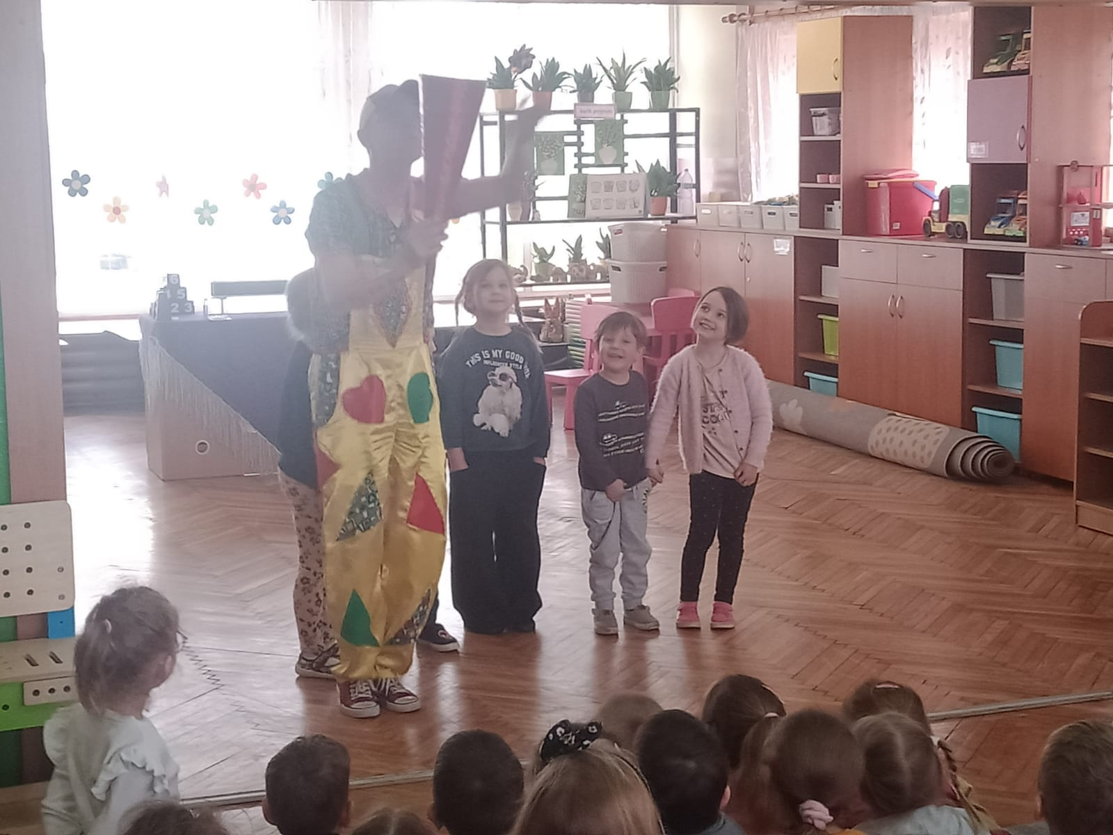 Troje dzieci uczestniczy w pokazie sztuczek cyrkowych