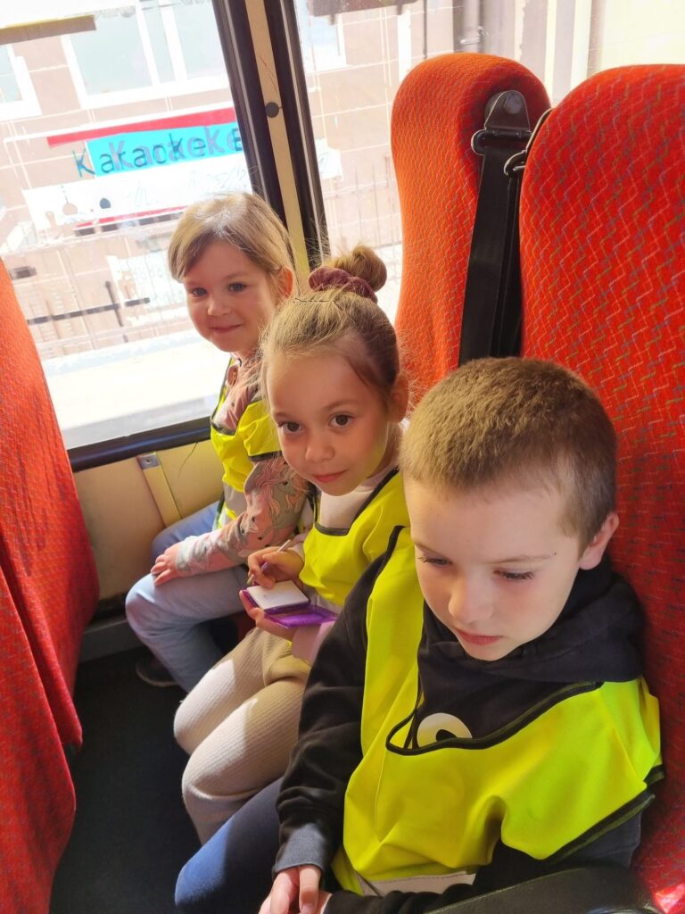 Trójka dzieci siedzi w autokarze