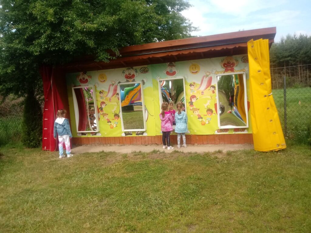 Dzieci przy ścianie deformujących luster