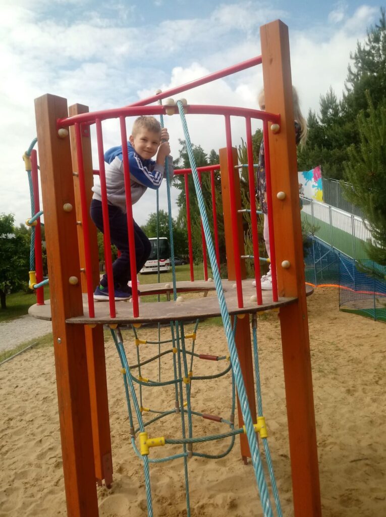 Chłopiec bawi się na placu zabaw
