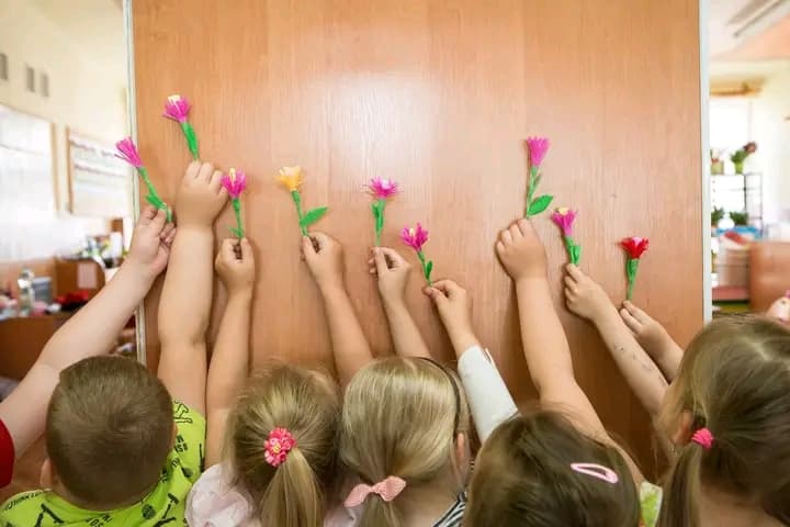 Dzieci pokazują samodzielnie wykonane ludowe kwiatki