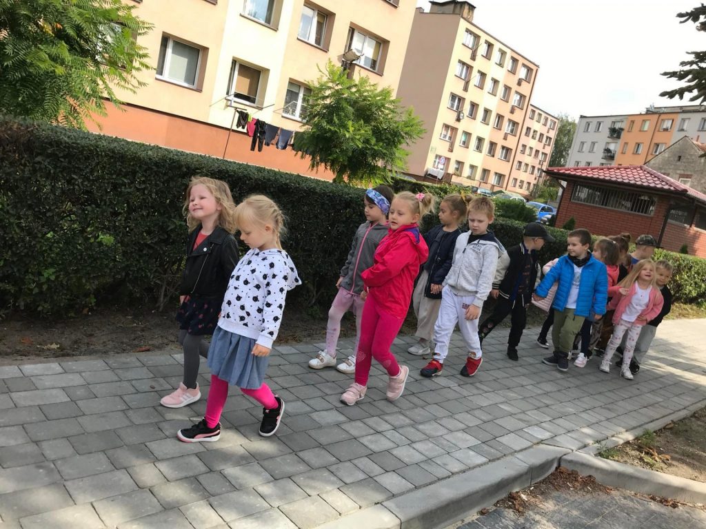 Dzieci spacerują chodnikiem.