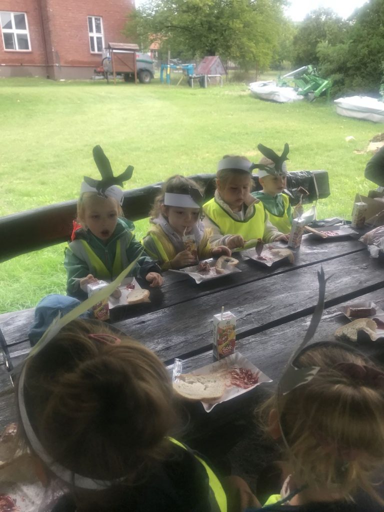 Dzieci jedzą kiełbaskę z grilla