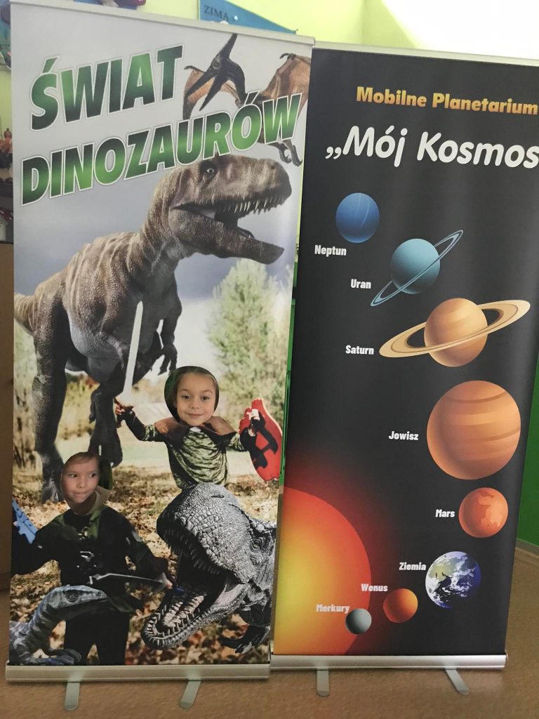 Dzieci pozują przy makiecie dinozaura.