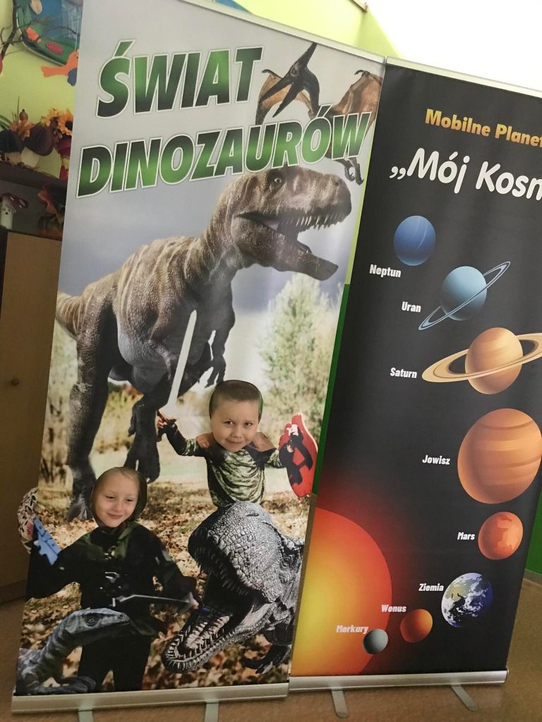 Dzieci pozują przy makiecie dinozaura.