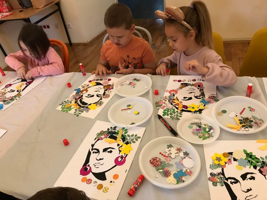 Dzieci ozdabiają obrazek Fridy Kahlo.