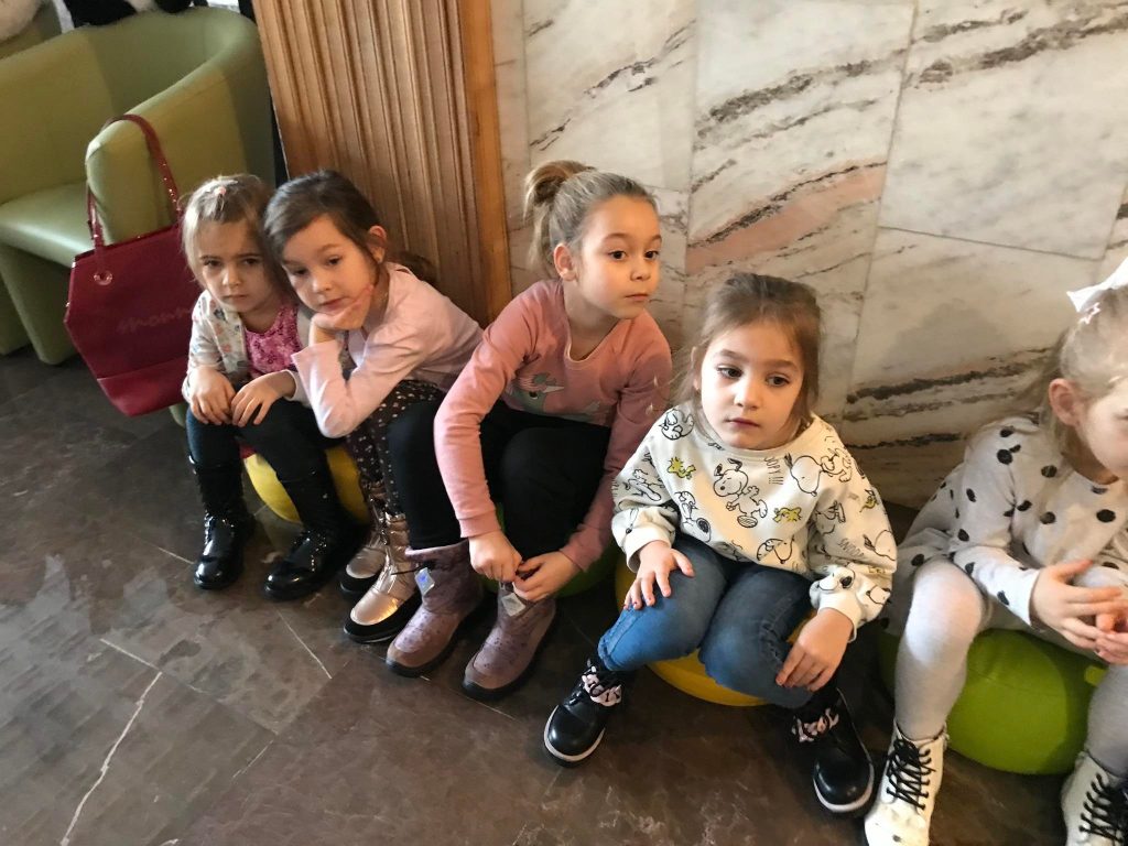 Dziewczynki siedzą na kolorowych pufach.