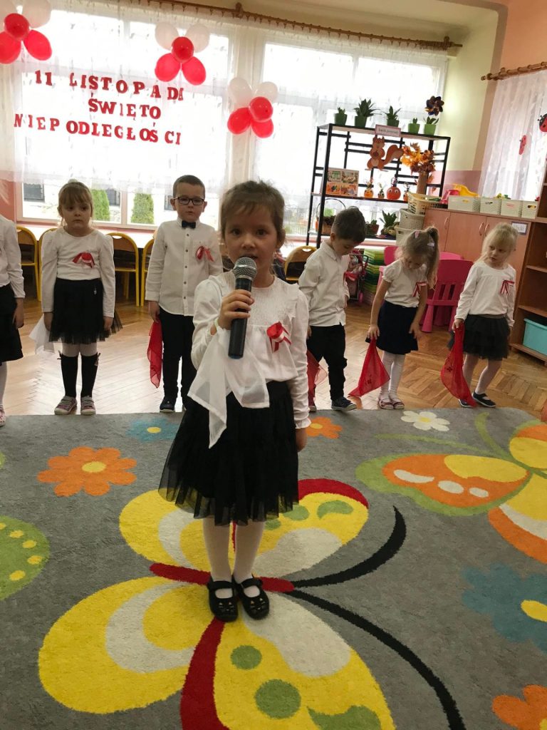 Dziewczynka recytuje wiersz do mikrofonu.