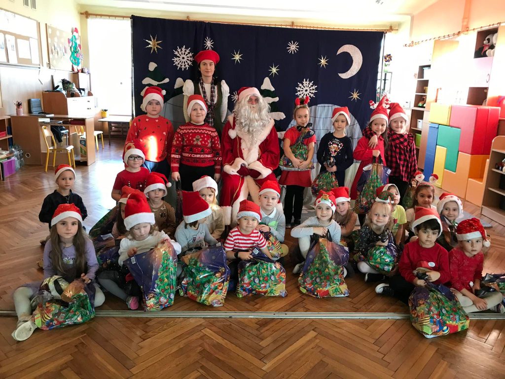 Dzieci z prezentami i święty Mikołaj.