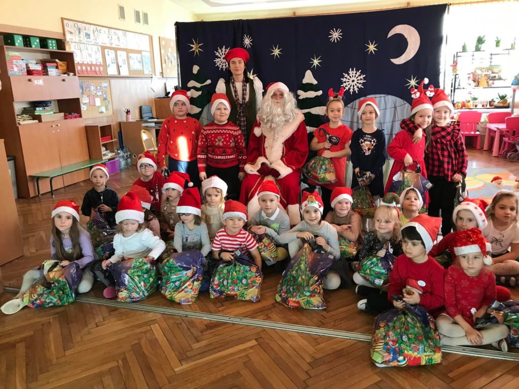 Dzieci z prezentami i święty Mikołaj.
