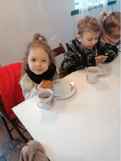 Dzieci piją herbatę i jedzą pyszne racuszki