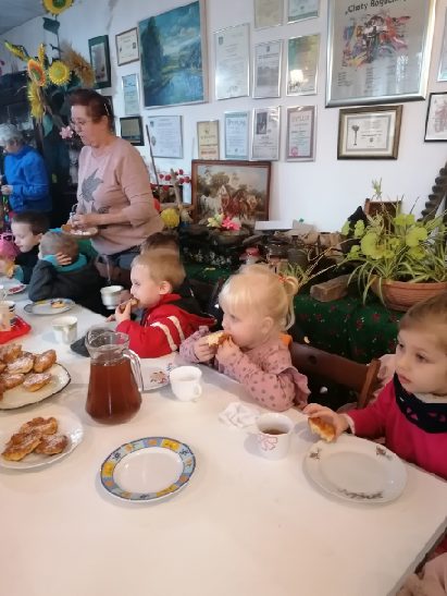 Dzieci piją herbatę i jedzą pyszne racuszki