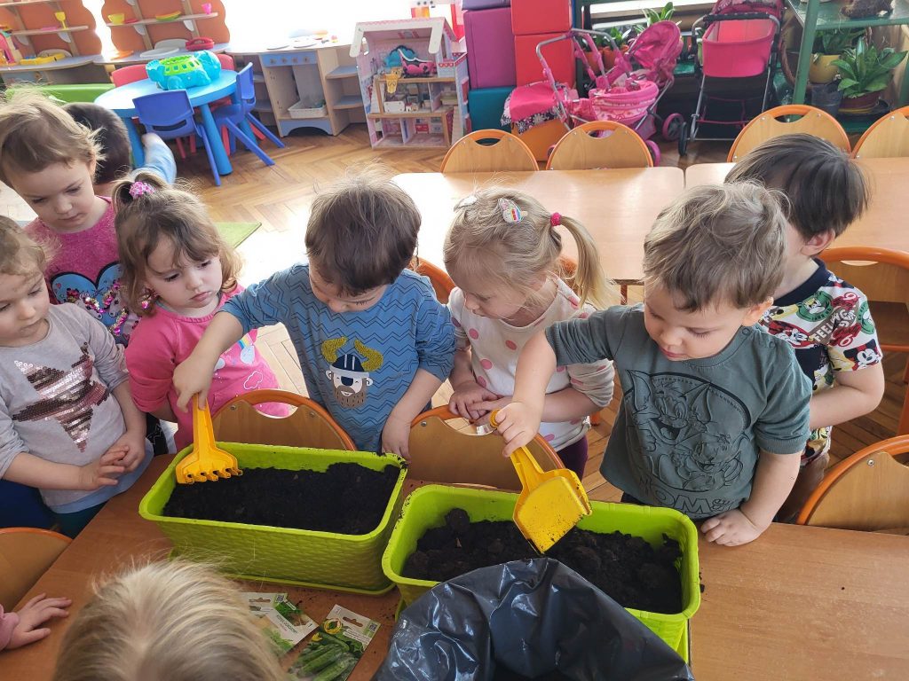 Dzieci sieją nasiona w doniczce