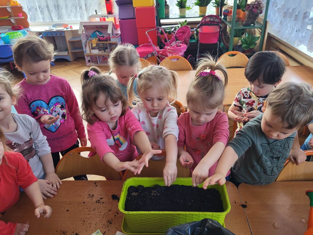 Dzieci sieją nasiona w doniczce