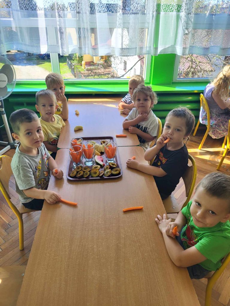 Przedszkolaki jedzą owocowy poczęstunek