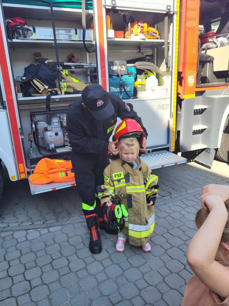 Dziewczynka przymierza strój strażaka