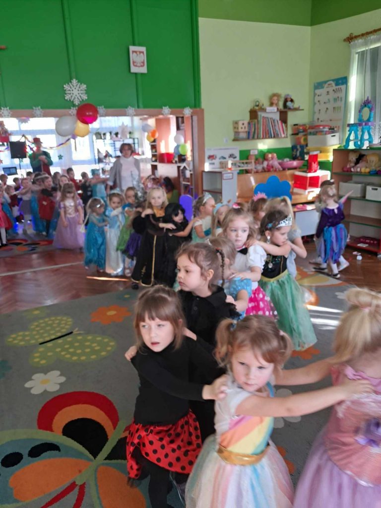 Dzieci w kolorowych przebraniach uczestniczą w zabawie karnawałowej