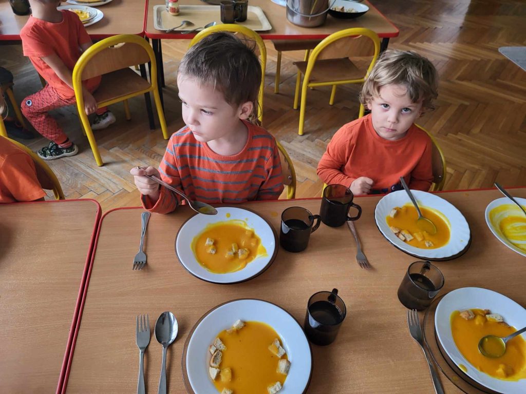 dzieci jedzą zupę dyniową