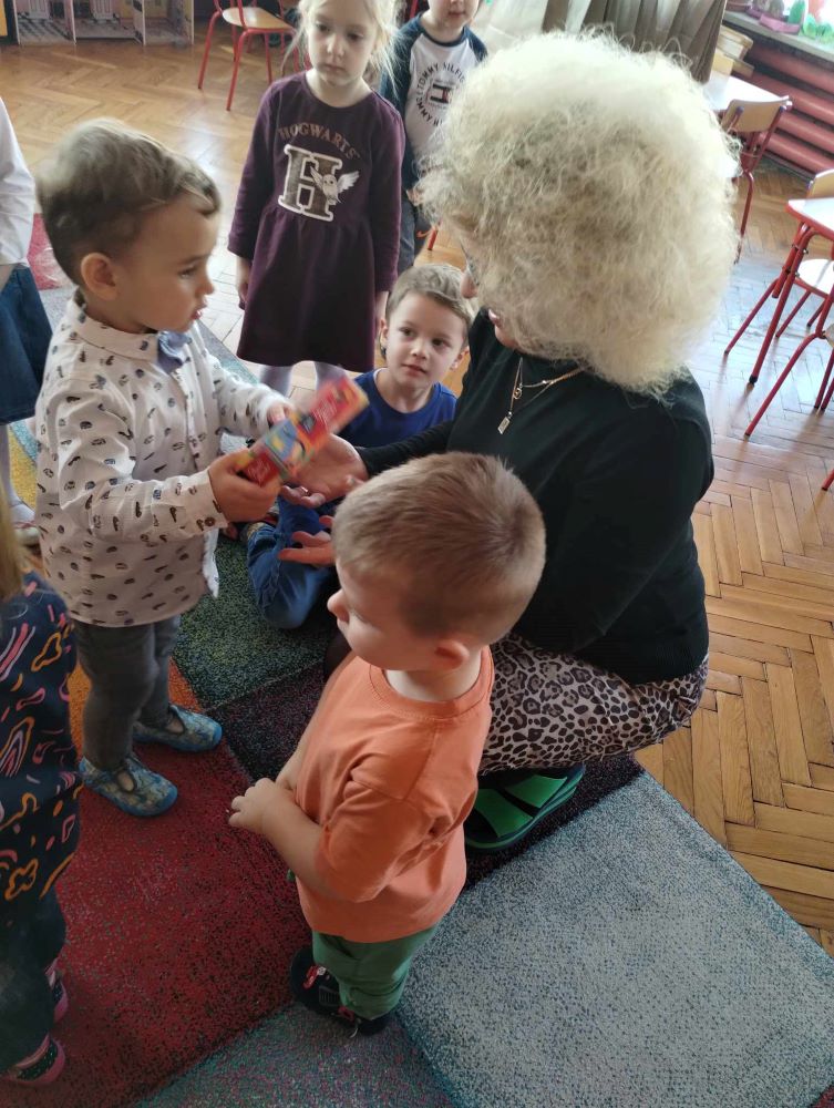 Dzieci z grupy Żabki wręczają słodkości naszym Drogim Panią z przedszkola z okazji Dnia Kobiet