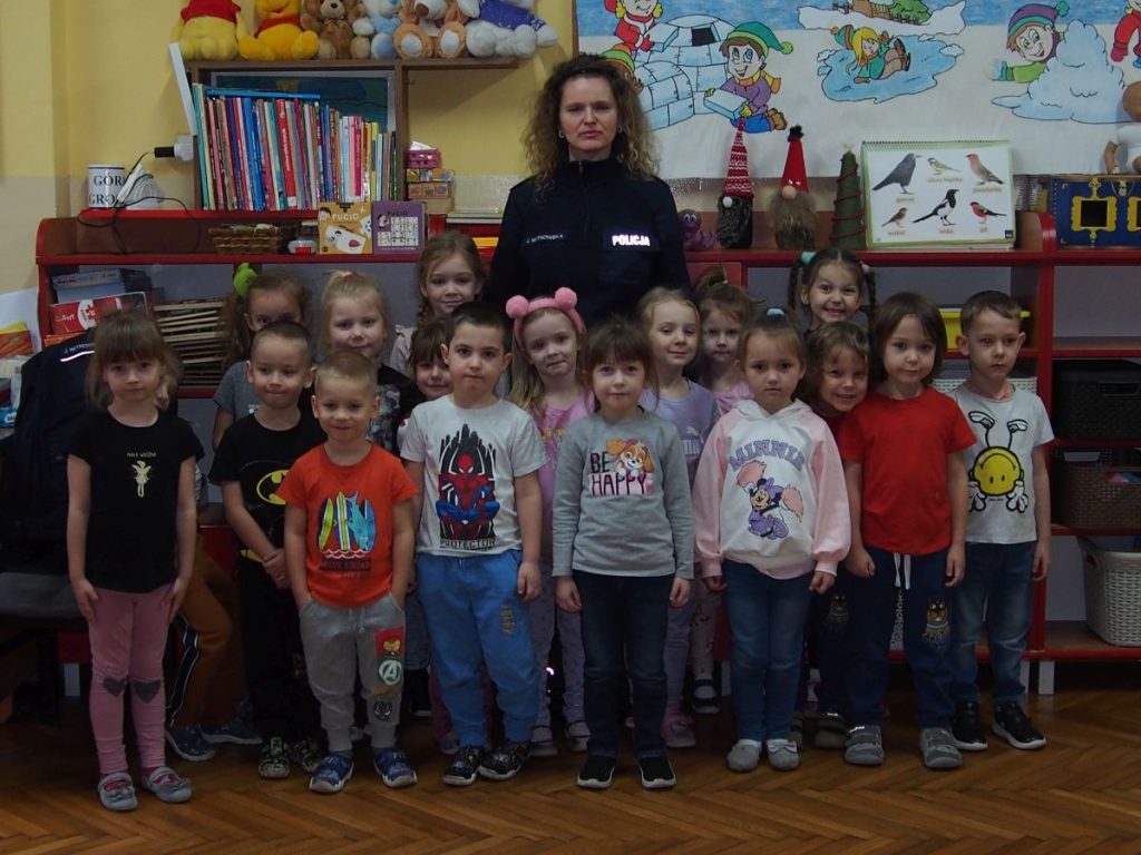 przedszkolaki z pięknym uśmiechem pozują do wspólnego zdjęcia z Panią Policjant
