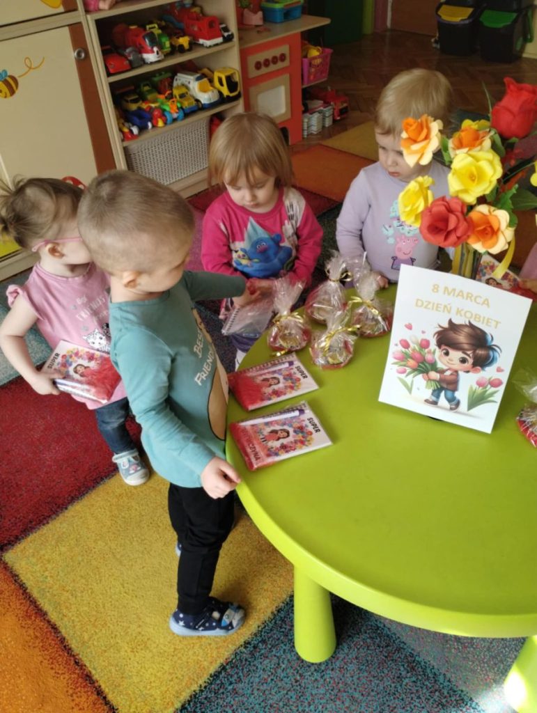 Chłopcy składają dziewczynką życzenia i dają małe upominki z okazji Dnia Kobiet