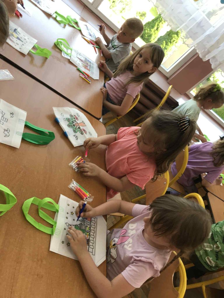 Dzieci kolorują torby.