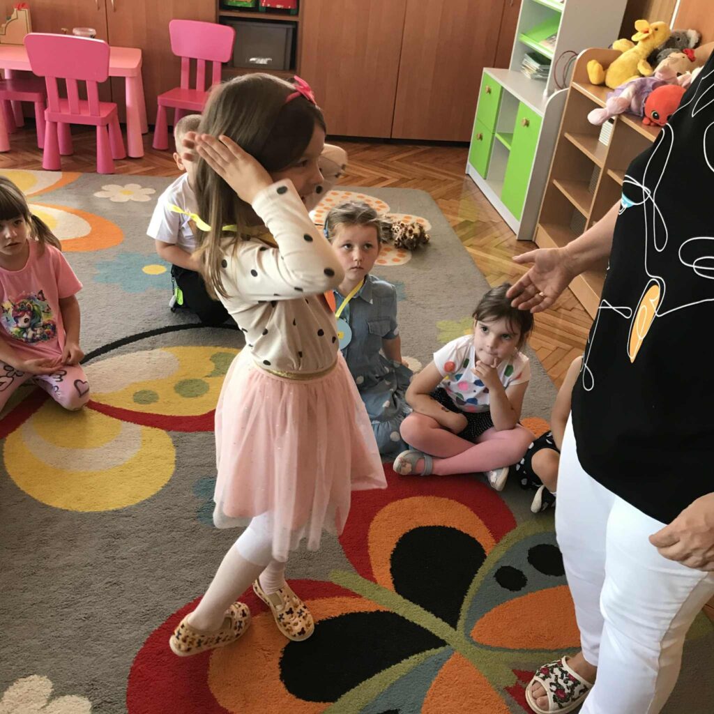 Dzieci otrzymują medal z kropek wyciętych z papieru.